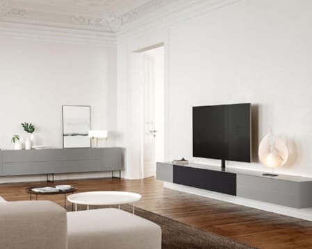 hell eingerichtetes Wohnzimmer mit TV und optisch passender Möbellösung